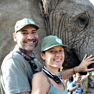 Man and woman posing with African Elephant.